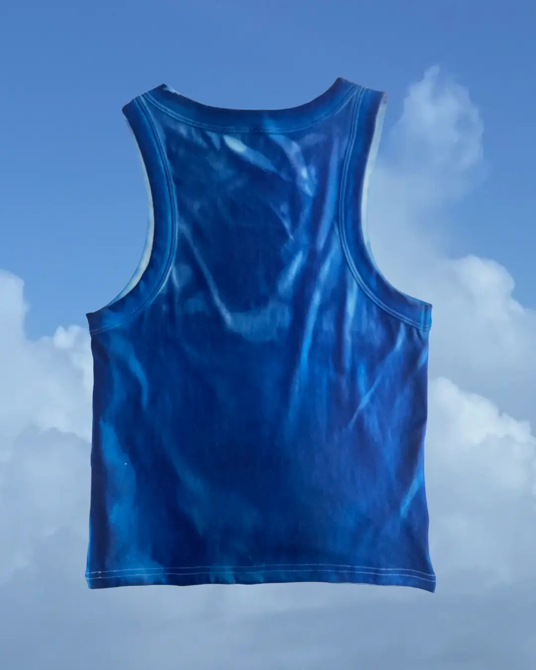 A blue sleeveless tank top shown from the back, floating against a sky-blue background with white clouds.